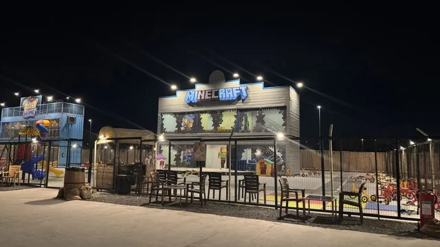 An entertainment game for children in the South West (Cowboy) town in the Al-Zahra neighborhood on King Abdulaziz Road in Jeddah for the year 2025, featuring buildings in classic Western style, a tourist entertainment destination, a place to have a good time in the Kingdom of Saudi Arabia, wearing American cowboy attire.