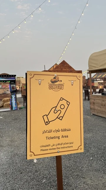 A place to have a good time in the Kingdom of Saudi Arabia, buildings in the classic Western style, a sign directing to the ticket purchase location in the South West Town (Cowboy) in the Al-Zahra neighborhood on King Abdulaziz Road in the city of Jeddah for the year 2025, wearing American cowboy attire. A place to have a good time in the Kingdom of Saudi Arabia, buildings in the classic Western style, a sign directing to the ticket purchase location in the South West Town (Cowboy) in the Al-Zahra neighborhood on King Abdulaziz Road in the city of Jeddah for the year 2025, wearing American cowboy attire.