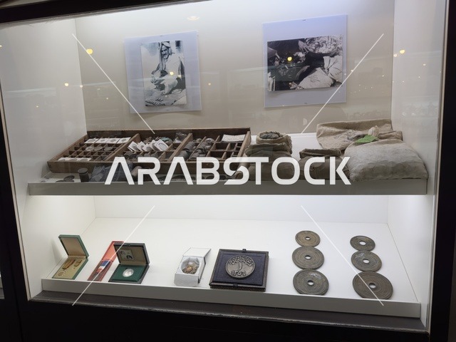 مجموعة من القطع الأثرية والعملات القديمة، الجزء العلوي من العرض صور بالأبيض والأسود، صممت القرية لتعكس العمارة التقليدية للمنطقة، القرية الشعبية التراثية متحف ومطعم بارز يقع على كورنيش الدمام في المملكة العربية السعودية