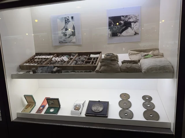 مجموعة من القطع الأثرية والعملات القديمة، الجزء العلوي من العرض صور بالأبيض والأسود، صممت القرية لتعكس العمارة التقليدية للمنطقة، القرية الشعبية التراثية متحف ومطعم بارز يقع على كورنيش الدمام في المملكة العربية السعودية