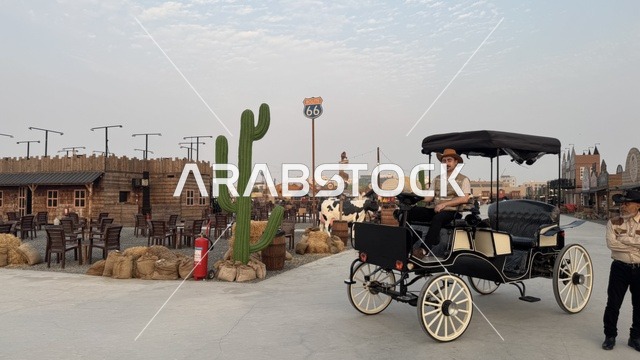 سيارة بشكل عربة حصان تقليدية للتنقل في بلدة ساوث ويست (الكاوبوي) في حي الزهراء على طريق الملك عبد العزيز في مدينة جدة لعام 2025، ارتداء زي الكاوبوي الامريكية، وجهه سياحية ترفيهية، مكان لقضاء وقت ممتع في المملكة العربية السعودية، مباني على الطراز الكلاسيكي الغربي
