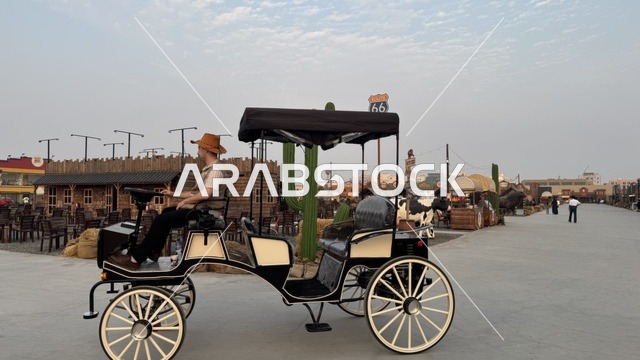 سيارة بشكل عربة حصان تقليدية للتنقل في بلدة ساوث ويست (الكاوبوي) في حي الزهراء على طريق الملك عبد العزيز في مدينة جدة لعام 2025، ارتداء زي الكاوبوي الامريكية، وجهه سياحية ترفيهية، مكان لقضاء وقت ممتع في المملكة العربية السعودية، مباني على الطراز الكلاسيكي الغربي