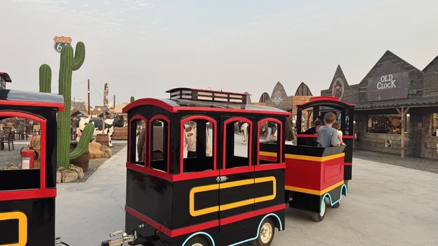 قطار صغير للتنقل في بلدة ساوث ويست (الكاوبوي) في حي الزهراء على طريق الملك عبد العزيز في مدينة جدة لعام 2025، ارتداء زي الكاوبوي الامريكية، وجهه سياحية ترفيهية، مكان لقضاء وقت ممتع في المملكة العربية السعودية، مباني على الطراز الكلاسيكي الغربي