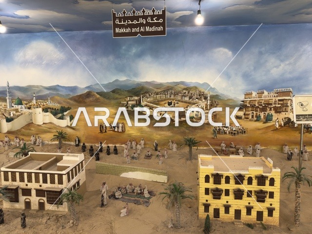 A colored image of Mecca and Medina in the past at the Heritage Village on the Corniche of Dammam, a cultural and tourist landmark that combines heritage, restaurants, and cafes, a place to spend enjoyable time with family in the Kingdom of Saudi Arabia.