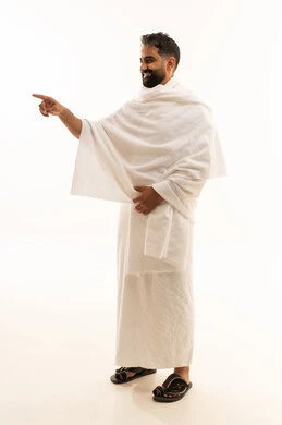 تحديد مكان معين، ايماءات السعادة لرؤية شيء ما، بورتريه لشاب مسلم عربي سعودي خليجي يرتدي ملابس الاحرام يشير بأصبع السبابة نحو شيء ما، آداء مناسك الحج والعمرة، الجسم بالطول الكامل، خلفية بيضاء