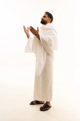 تعابير التوسل والاسترحام، التضرع إلى الله تعالى، طلب المساعدة من المولى عز وجل، مفهوم الاجتهاد في العبادة، ، بورتريه  لرجل عربي خليجي سعودي يرتدي ملابس الاحرام يرفع ييه بايماءات الدعاء، آداء مناسك الحج والعمرة، صورة لكامل الجسم، خلفية بيضاء