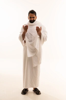الدعاء و التضرع لرب العباد، مفهوم أركان الإسلام، اداء مناسك الحج والعمرة، العبادة والتقرب الى الله، بورتريه لرجل عربي خليجي سعودي يرتدي لباس الاحرام يرفع يديه بايماءات الدعاء، الجسم بالطول الكامل، خلفية بيضاء