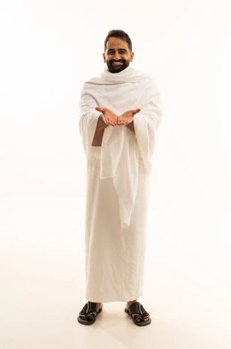 The concept of demand and the need for assistance, presenting and displaying something, performing the rituals of Hajj and Umrah, a portrait of a smiling Saudi Gulf Muslim man wearing Ihram clothes, opening his palms in gestures attempting to carry something, full-body, white background.