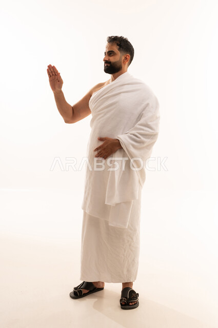 تعابير الحزم والجدية, طلب التوقف وعدم الاقتراب, مفهوم الرفض والامتناع والانزعاج,  بورتريه لرجل عربي سعودي خليجي يرتدي ملابس الإحرام يمد يده نحو الأمام مع رفع الكف بإيماءات النهي عن فعل امر ما,أداء مناسك الحج والعمرة، صورة الجسم بالطول الكامل، خلفية بيضاء