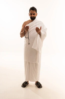 طلب العفو والمغفرة من الله تعالى، رفع الكفين نحو الأعلى والدعاء، العبادة والطاعة والإكثار من الأذكار, أداء مناسك الحج والعمرة، بورتريه لرجل عربي سعودي خليجي يرتدي ملابس الإحرام يمسك بيده السبحة ويدعو الله، الجسم بالطول الكامل، خلفية بيضاء