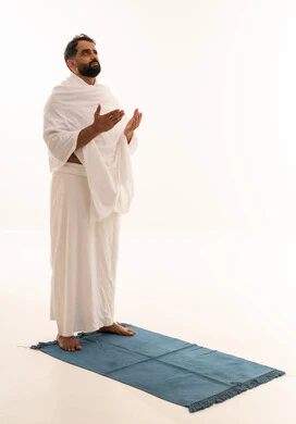 طلب العفو والمغفرة من الله تعالى، رفع الكفين نحو الأعلى والدعاء، العبادة والطاعة والإكثار من الأذكار, أداء مناسك الحج والعمرة، بورتريه لرجل عربي خليجي يرتدي ملابس الإحرام يدعو الله، الجسم بالطول الكامل، خلفية بيضاء