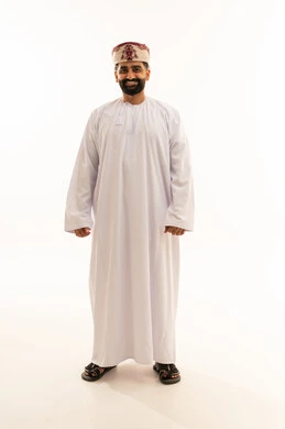 الوقوف باستقامة والنظر بايماءات الثقة بالنفس، مفهوم الرجولة والوقار، الاهتمام بالمظهر الخارجي، بورتريه لرجل عربي خليجي عماني يرتدي الدشداشة والعمامة يقف باستقامة، صورة الجسم بالطول الكامل، خلفية بيضاء