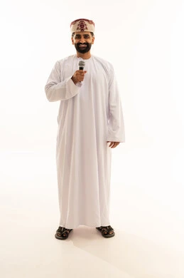 تبادل الحوار والاستفادة من الخبرات، إلقاء المحاضرات وإقامة الندوات، بورتريه لرجل عربي خليجي عماني يرتدي الدشداشة و العمامة ينظر الى الكاميرا بتعابير السرور، العمل في تقديم الفقرات والبرامج الفنية الترفيهية، الجسم بالطول الكامل، خلفية بيضاء