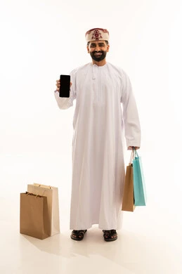 A black screen displayed on a mobile phone, buying gifts and supplies, taking advantage of seasonal offers and discounts, a portrait of an Arab Gulf Omani man wearing a dishdasha and a turban holding colorful paper bags in gestures of joy and happiness, full-body, white background.