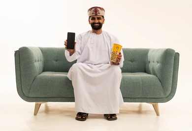 عرض خلفية شاشة سوداء على الهاتف المحمول، تناول الفوشار اللذيذ،بورتريه لرجل عربي خليجي عماني يرتدي الدشداشة و العمامة يجلس على الاريكة يحمل بيده علبة من الفشار الطازة ، الترفيه عن النفس وقضاء وقت ممتع، خلفية بيضاء