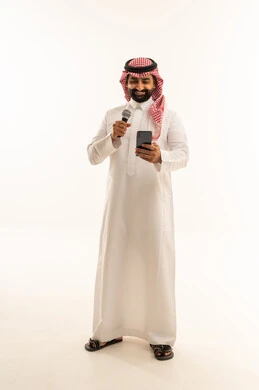 Musical theatrical art, practicing the hobby of singing for fun and entertainment, artistic talents in the world of music, presenting the theatrical performance, a portrait of a Saudi Gulf Arab man wearing a thobe and a ghutrah holding a microphone and a mobile phone in his hand, full-body, white background.