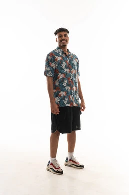 Standing sideways and looking at the camera with a smile, an Arab Gulf Omani man wearing casual attire, gestures of happiness, portrait with a white background, full body.