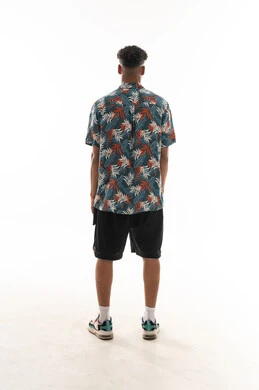 A Gulf Arab Omani man wearing casual attire stands in the back in front of the camera, portrait with a white background, full body.