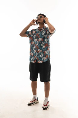 Looking up while listening to music and smiling is a sign of enjoyment and spending special moments. An Arab Gulf Omani man wearing casual attire is wearing headphones, showing gestures of happiness, full-body, portrait with a white background.