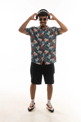 رجل عربي خليجي عماني يرتدي الزي الكاجوال يرفع سماعة الراس من على الاذن بعد الانتهاء من سماع الموسيقى , ايماءات السعادة و الابتسامة , الجسم بالطول الكامل , بورتريه خلفية بيضاء