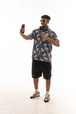 Thumbs up as a sign of approval, an Arab Gulf Omani man wearing casual attire using live video call applications, gestures of happiness, full body, portrait with a white background.