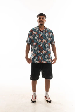 رجل عربي خليجي عماني يرتدي الزي الكاجوال , الوقوف امام الكاميرا , امساك طرفي القميص من اسفل في سعادة اشارة الي الاناقة , بورتريه خلفية بيضاء , الجسم بالطول الكامل