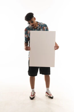 النظر الى ورقة بيضاء كبيرة فارغة , رجل عربي خليجي عماني يرتدي الزي الكاجوال يحمل يافطة امام الكاميرا , بورتريه خلفية بيضاء , الجسم بالطول الكامل