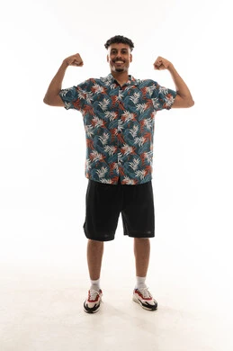 الوقوف امام الكاميرا و الاعجاب بقوة الجسد , رجل عربي خليجي عماني يرتدي الزي الكاجوال يثني الذراعين و يستعرض العضلات القوية , بورتريه خلفية بيضاء , الجسم بالطول الكامل