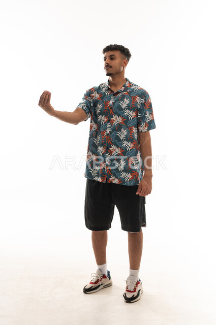 ضم اصابع اليد و التلويح بها في الهواء اشارة الى طلب التمهل و الانتظار , رجل عربي خليجي عماني يرتدي الزي الكاجوال , بورتريه خلفية بيضاء , الجسم بالطول الكامل