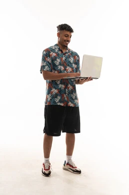 ارسال الرسائل الالكترونية و كتابة تقارير المهام اليومية بسهولة , رجل عربي خليجي عماني يرتدي الزي الكاجوال يحمل جهاز الحاسب المتنقل , النقر على لوحة المفاتيح , بورتريه خلفية بيضاء , ايماءات البهجة و السعادة , الجسم بالطول الكامل