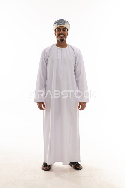 بورتريه خلفية بيضاء , لقطة امامية للكاميرا , الجسم بالطول الكامل , رجل عربي خليجي عماني يرتدي الدشداشة البيضاء و العمامة , ايماءات السعادة و الفرحة