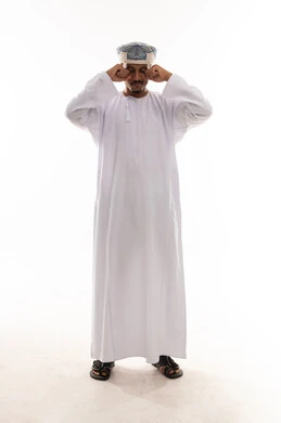 الشعور بالنعاس و الخمول , رجل عربي خليجي عماني يرتدي الدشداشة البيضاء و العمامة يفرك عينه باصابع اليد , الوقوف امام الكاميرا , الجسم بالطول الكامل , بورتريه خلفية بيضاء