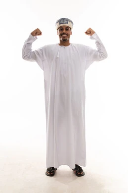 استعراض القوة الجسدية , رجل عربي خليجي عماني يرتدي الدشداشة البيضاء و العمامة يثني الذراعين و يظهر عضلاته , الجسم بالطول الكامل , بورتريه خلفية بيضاء