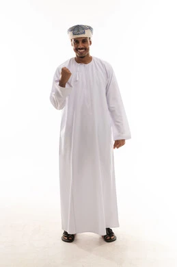 Clenching the fist tightly and raising it upwards is a sign of victory and challenge. An Arab Gulf Omani man wearing a white dishdasha and turban, gestures of happiness and a smile, full-body, portrait with a white background.