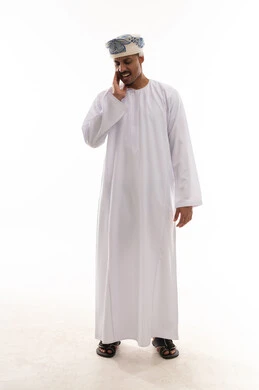 تعابير الشعور بالالم والانزعاج من الاسنان , رجل عربي خليجي عماني يرتدي الدشداشة البيضاء و العمامة يشعر بوجع الاسنان الشديد ,وضع اصابع اليد على الخد , بورتريه خلفية بيضاء , الجسم بالطول الكامل