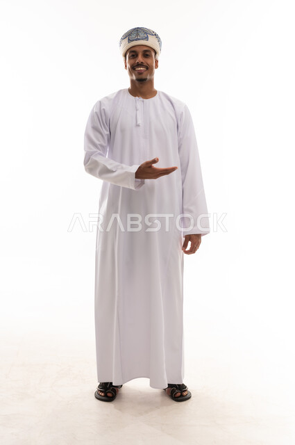 فتح قبضة اليد اشارة الي الترحيب , رجل عربي خليجي عماني يرتدي الدشداشة البيضاء و العمامة , ايماءات السرور و البهجة , بورتريه خلفية بيضاء , الجسم بالطول الكامل , النظر للكاميرا