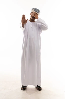 The palm is raised as a signal to stop, and the other hand is placed over the eyes. An Arab Gulf Omani man is wearing a white dishdasha and a turban, covering his eyes to prevent vision. Portrait with a white background, full-body, expressions of discomfort.