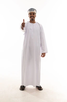 رفع اصبع الابهام لاعلى اشارة الي الاعجاب و الموافقة , رجل عربي خليجي عماني يرتدي الدشداشة البيضاء و العمامة يقف امام الكاميرا بالطول الكامل , ايماءات السرور و الابتسامة , بورتريه خلفية بيضاء