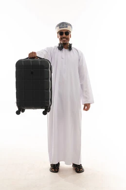 ايماءات السعادة اثناء التحضير للسفر , رجل عربي خليجي عماني يرتدي دشداشة و عمامة يرفع حقيبة سفر صغيرة للاعلى , الجسم بالطول الكامل , الوقوف امام الكاميرا , بورتريه خلفية بيضاء