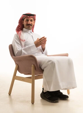 Saudi Man in Traditional Thobe Sitting on White Background