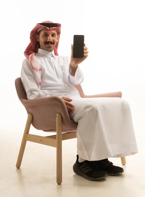 Saudi Man Holding Smartphone Against White Background