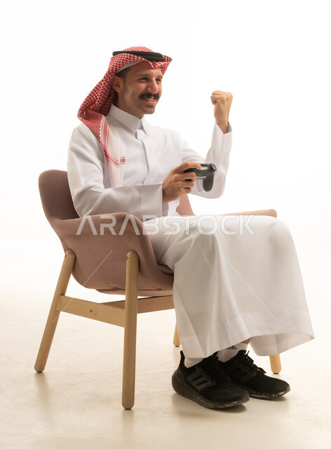 رجل سعودي يلعب ألعاب الفيديو بخلفية بيضاء