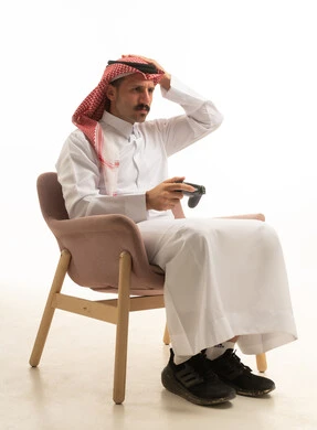 رجل سعودي يلعب ألعاب الفيديو بتعبير محبط