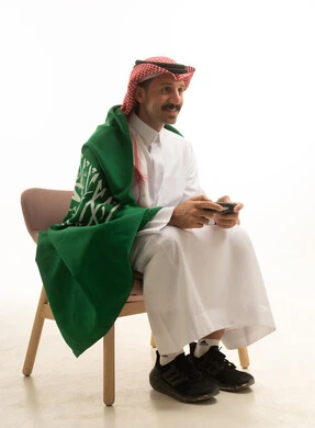 Saudi Man Gaming with Controller and National Flag