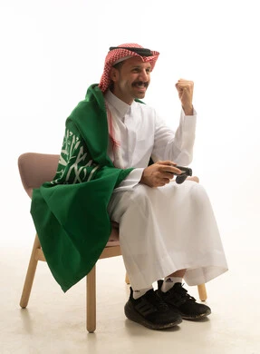 رجل سعودي يلعب ألعاب الفيديو بالعلم الوطني