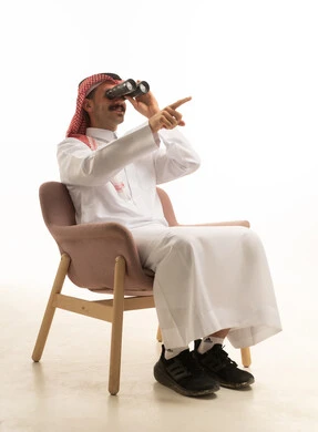 رجل سعودي مع منظار يشير للأمام