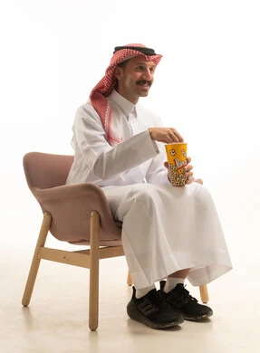 Saudi Man in Traditional Attire Eating Popcorn Studio Shot