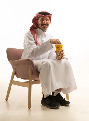رجل سعودي بالزي التقليدي يأكل الفشار في الاستوديو