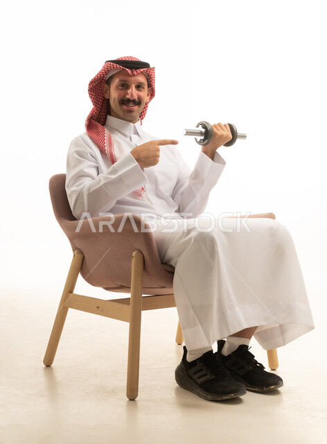 Saudi Man in Thobe Exercising with Dumbbell