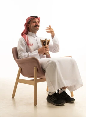 رجل سعودي بالزي التقليدي يحمل مبخرة في الاستوديو